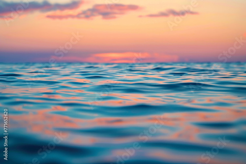 The ocean is calm and the sky is a beautiful pink color