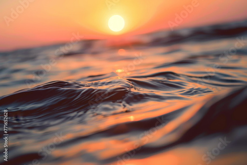 The sun is setting over the ocean, casting a warm glow on the water