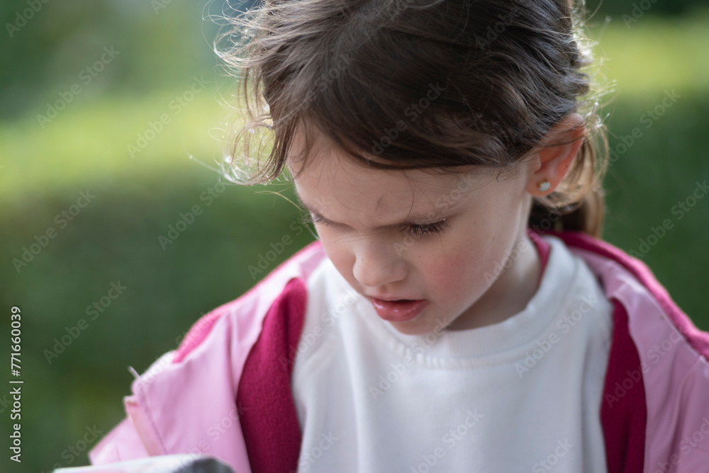 Little girl playing on a playground in the garden on a sunny day. Shallow depth of field Little girl playing on a playground in the garden on a sunny day. Shallow depth of field