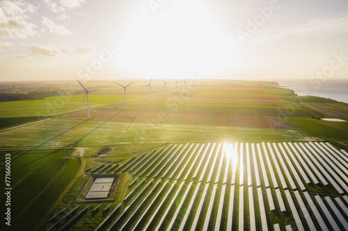 Wind turbines and solar panels farm in a field. Renewable green energy. Sunny landscape, electric energy generator for clean energy producing concept