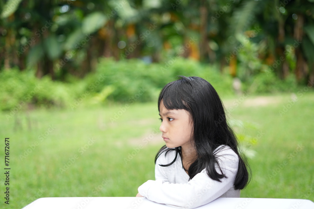 The sullen expression of an Asian girl with a flat face The sullen expression of an Asian girl with a flat face
