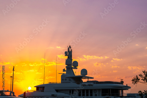 the upper part is the roof of a luxurious white yacht against a sunset sky