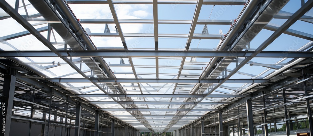 Admiring the symmetry of the metal beams in the composite material roof, with tints and shades, from the clear glass ceiling of the building Admiring the symmetry of the metal beams in the composite material roof, with tints and shades, from the clear glass ceiling of the building