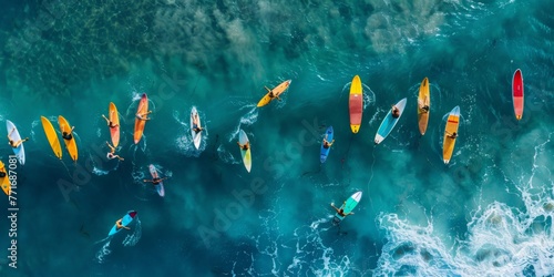 Aerial view of surfers on colorful boards waiting for waves. Summer surfing session. © olga_demina