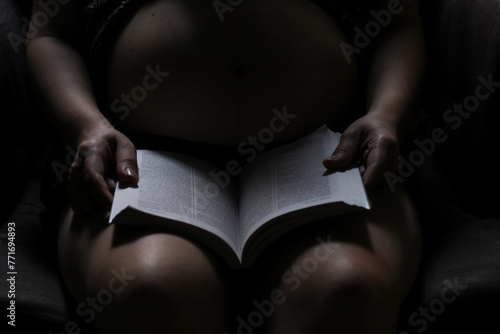 mujer embarazada meditando y leyendo libro sagrado.