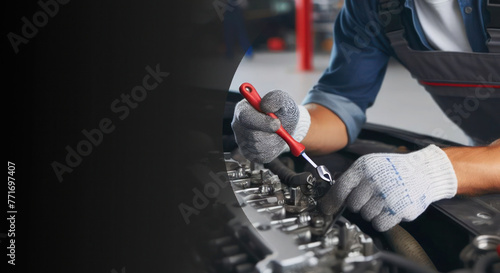 Skilled auto mechanic working on a car engine in a mechanic’s garage, providing repair service