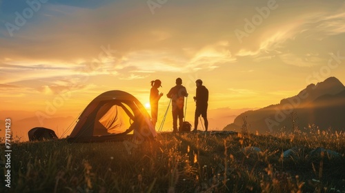 silhouette of Friends assembling tent at campsite near mountains