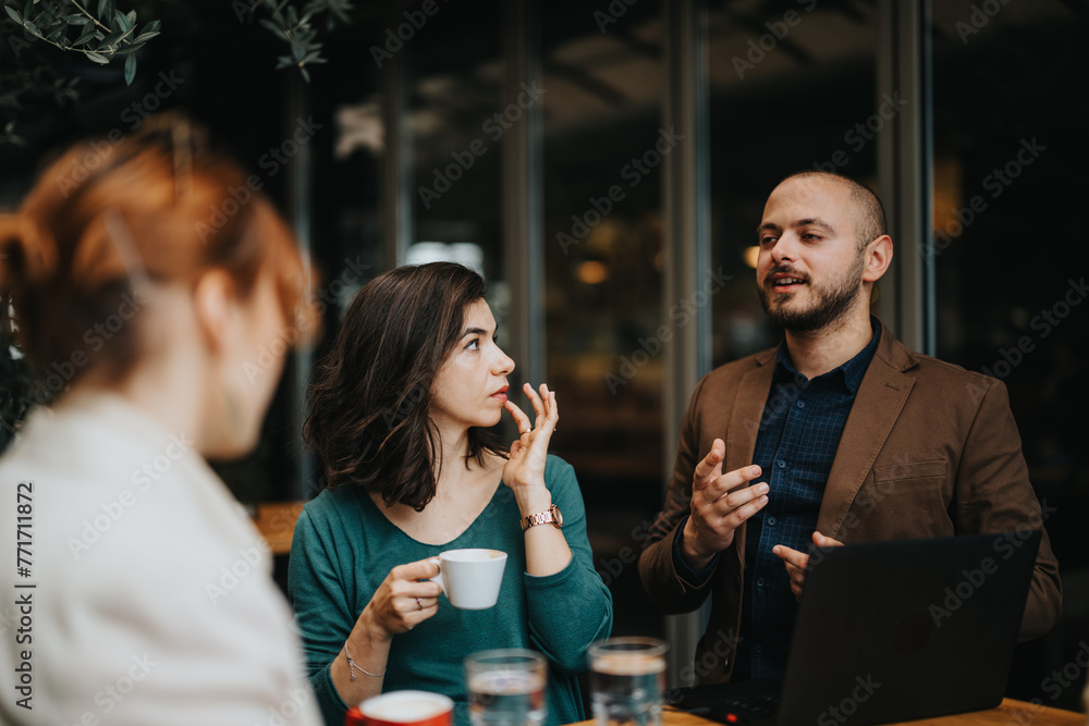 Dedicated business partners engage in a strategic conversation while enjoying coffee in a casual cafe setting. Dedicated business partners engage in a strategic conversation while enjoying coffee in a casual cafe setting.