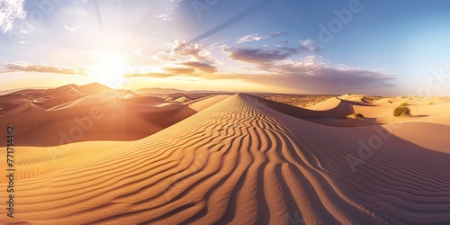 The sun is setting behind sand dunes in a natural colorful landscape