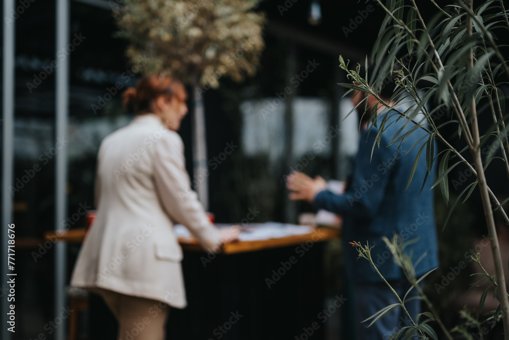Two business partners engage in a conversation over documents amidst natural surroundings Two business partners engage in a conversation over documents amidst natural surroundings