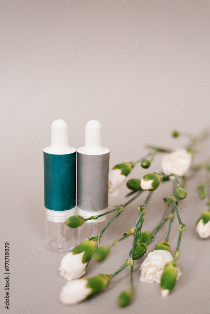 Two small bottles of liquid with a leaf in between them Two small bottles of liquid with a leaf in between them