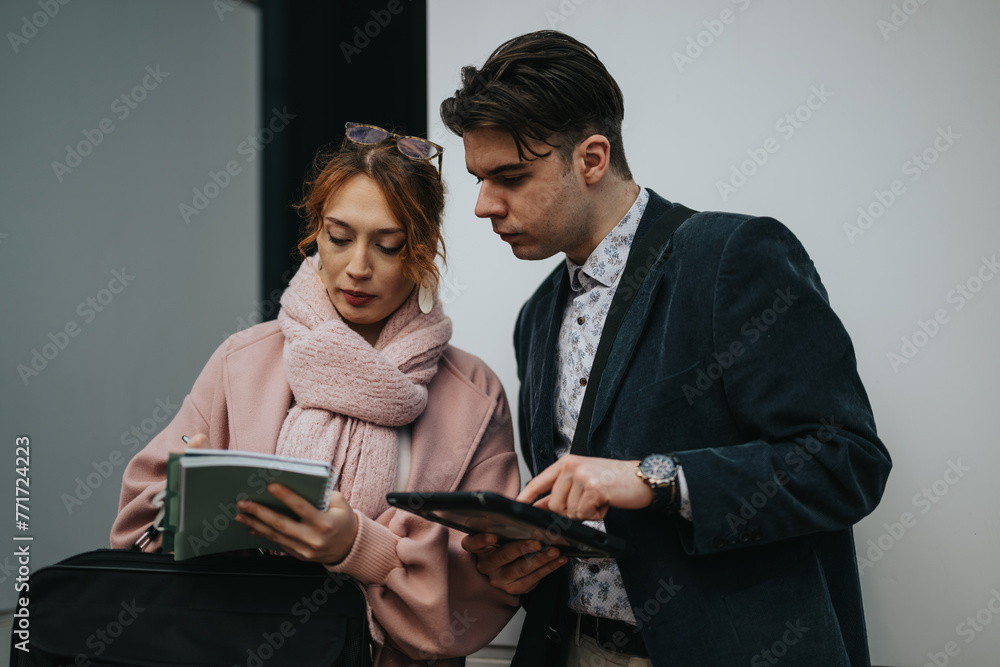 Entrepreneurial young man and woman collaborating and networking in a city environment, using digital tablets for research. Entrepreneurial young man and woman collaborating and networking in a city environment, using digital tablets for research.