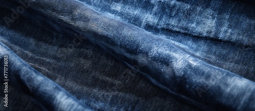 A close up of electric blue denim fabric with a unique pattern resembling a landscape made of wood and rocks against a dark horizon