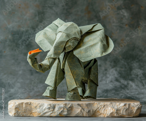 paper elephant - origami standing on a flat stone on a gray background