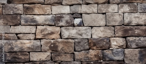 An upclose view of a brick wall constructed with rectangular bricks. The pattern creates a solid structure made of building material and composite stone