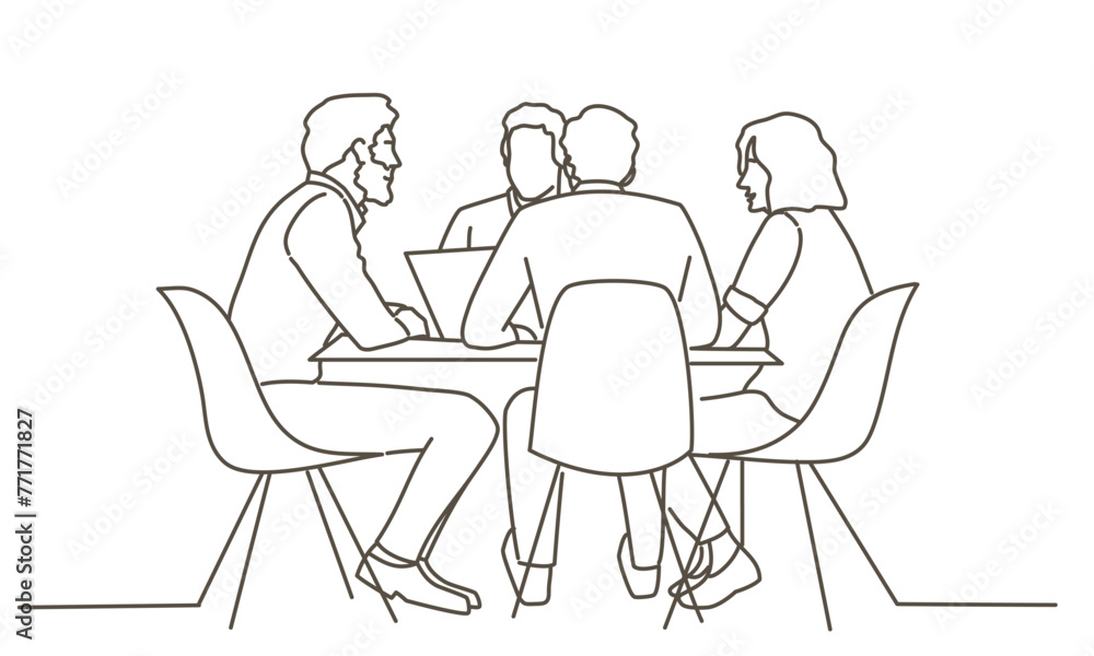 A group of people are sitting around a table, with one person using a laptop