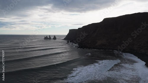 Aerial View of Reynisdrangar and Waves Crashing at Black Sand Beach in Vik i Myrdal at the Southern Coast of Iceland photo