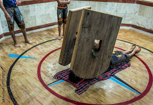 Obraz na płótnie Young man training with sang shields in Zoorkhaneh - traditional Iranian gym in Yazd city, Iran w salonie