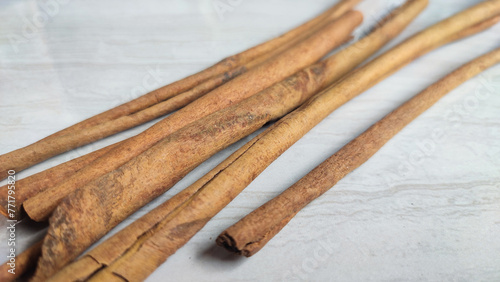 Pieces of dried cinnamon or Cinnamomum zeylanicum which is useful as a cooking spice and natural medicine, isolated on a patterned ceramic surface photo