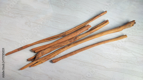 Pieces of dried cinnamon or Cinnamomum zeylanicum which is useful as a cooking spice and natural medicine, isolated on a patterned ceramic surface