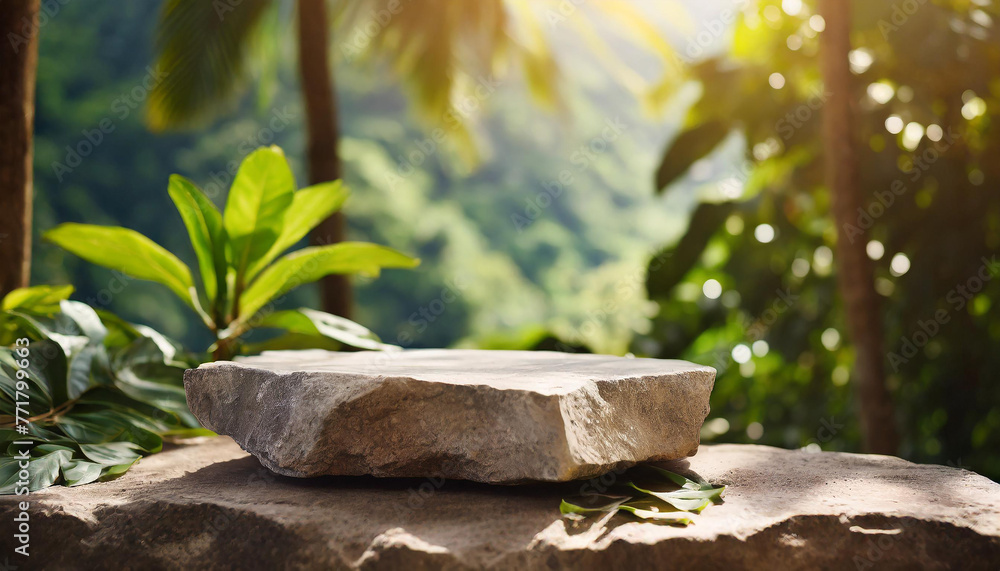 Gray stone podium, table top outdoors with tropical forest. Green leaves. Blurred natural backdrop.