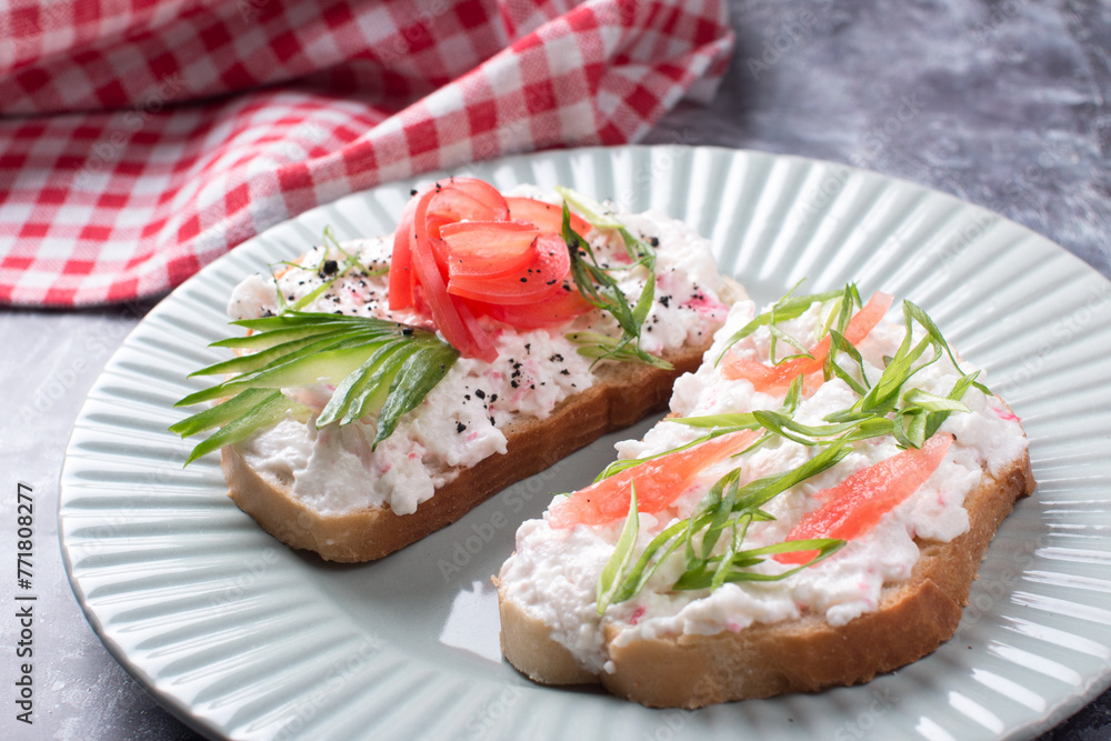Bruschetta, a slice of bread with cheese paste, tomato and cucumber. Beautifully decorated sandwiches on a plate Bruschetta, a slice of bread with cheese paste, tomato and cucumber. Beautifully decorated sandwiches on a plate