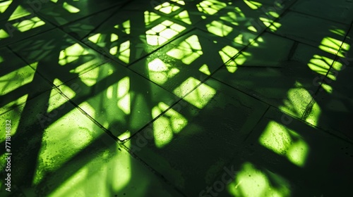 Intricate shadow play on floor under green lighting. Artistic green light creating abstract floor patterns. Green hues and shadows intersecting on a tiled floor.