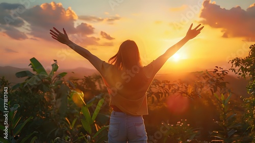 Happy woman standing with her back on sunset in nature iwith open hands. photo