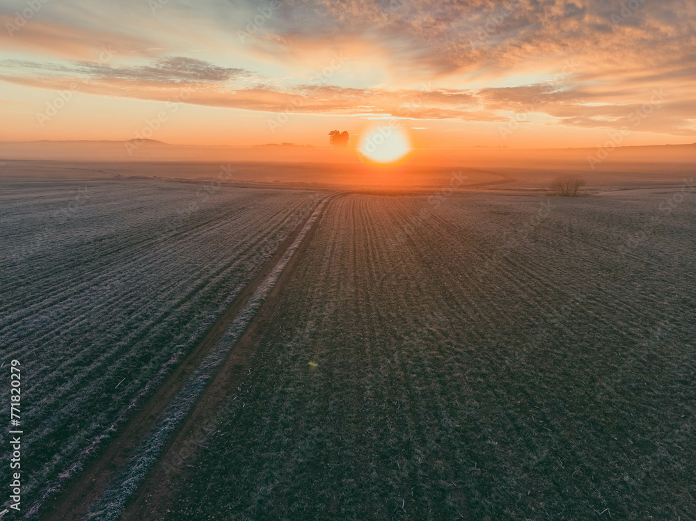 A sun is setting over a field of snow A sun is setting over a field of snow