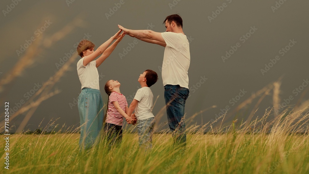 Family wants to buy house. Happy family shows house with their hands, symbol of safety, comfort for child. Happy family mother father daughter, son, kid, dream to build house, mortgage for family.