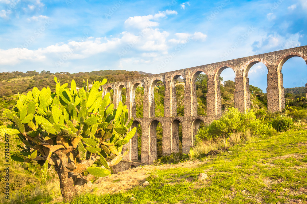 Aqueduct between mountains at sunset with cloudy sky in arcos del sitio in tepotzotlan state of mexico Aqueduct between mountains at sunset with cloudy sky in arcos del sitio in tepotzotlan state of mexico