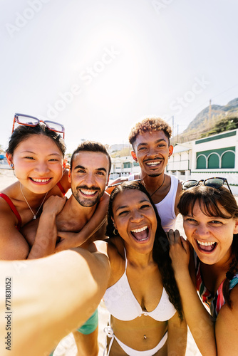 Diverse group of people having fun taking selfie portrait together enjoying summer vacation in the beach. Friendship and holidays concept.