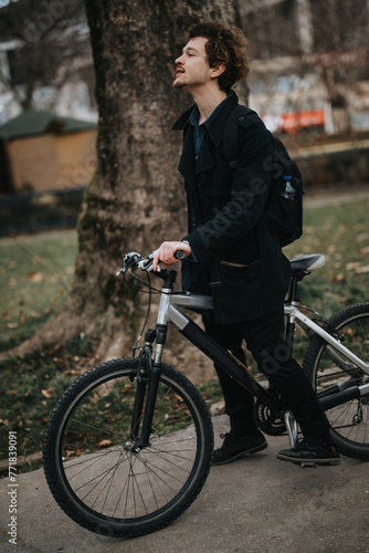 Fashionable young person with a bike, taking a break among trees in a city park setting.