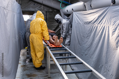 Foto A man in a yellow suit is sanitizing a man in a contaminated zone