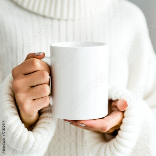 A woman in a white sweater holding up a coffee cup