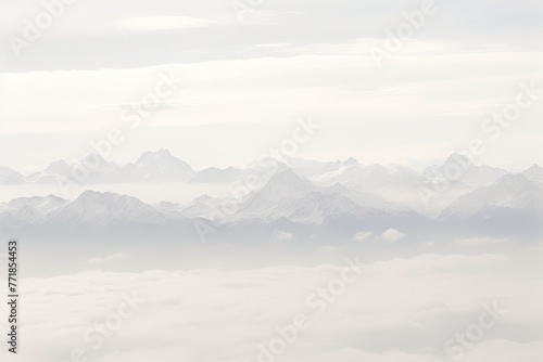 Aerial View of Misty Mountain Range Amid Soft White and Gray Clouds, Majestic Peaks Rising Above the Mist, Tranquil Landscape with a Hint of Mystery, Nature Photography. © katrin888