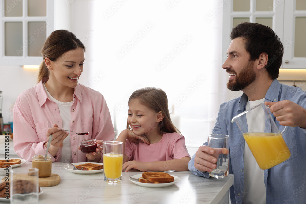 Happy family having breakfast at table in kitchen