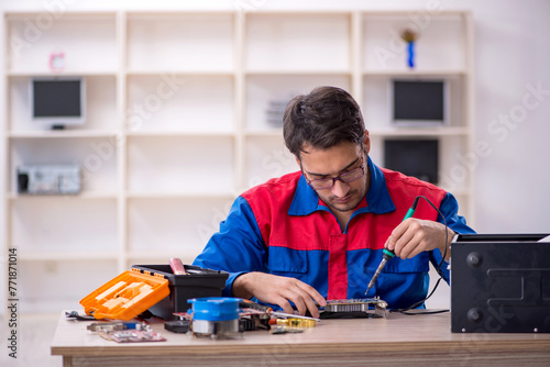 Young male repairman repairing computer