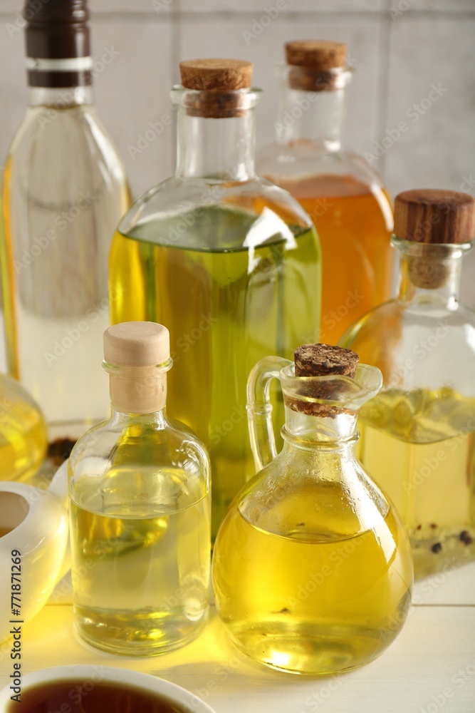 Vegetable fats. Different oils in glass bottles on white table, closeup Vegetable fats. Different oils in glass bottles on white table, closeup