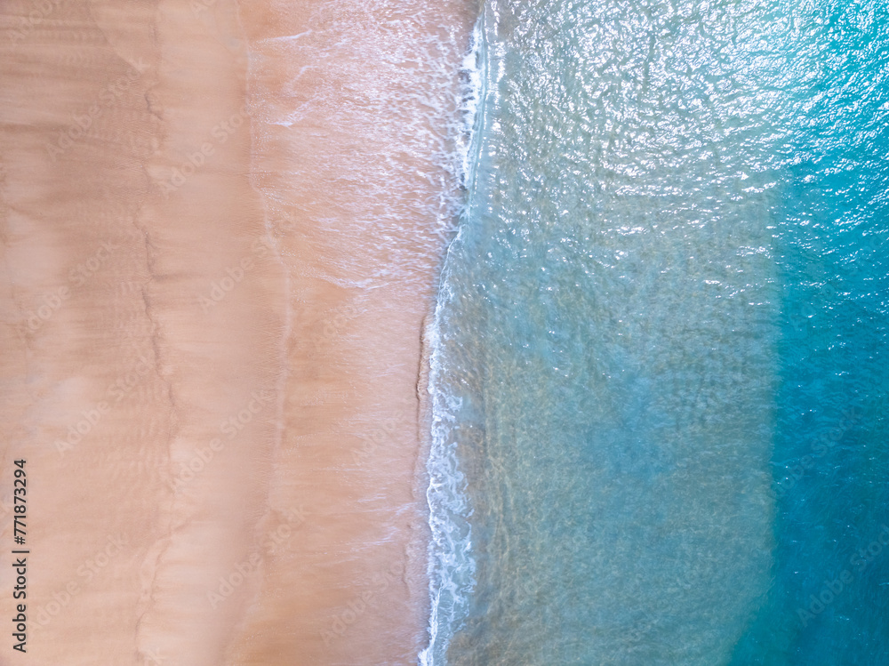 Fototapeta premium Amazing Top view sea beach landscape background,Summer sea waves crashing on sandy shore seascape background,High angle view ocean nature background