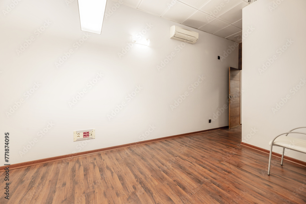 A small empty office with an armchair with white seats and a reddish floor A small empty office with an armchair with white seats and a reddish floor