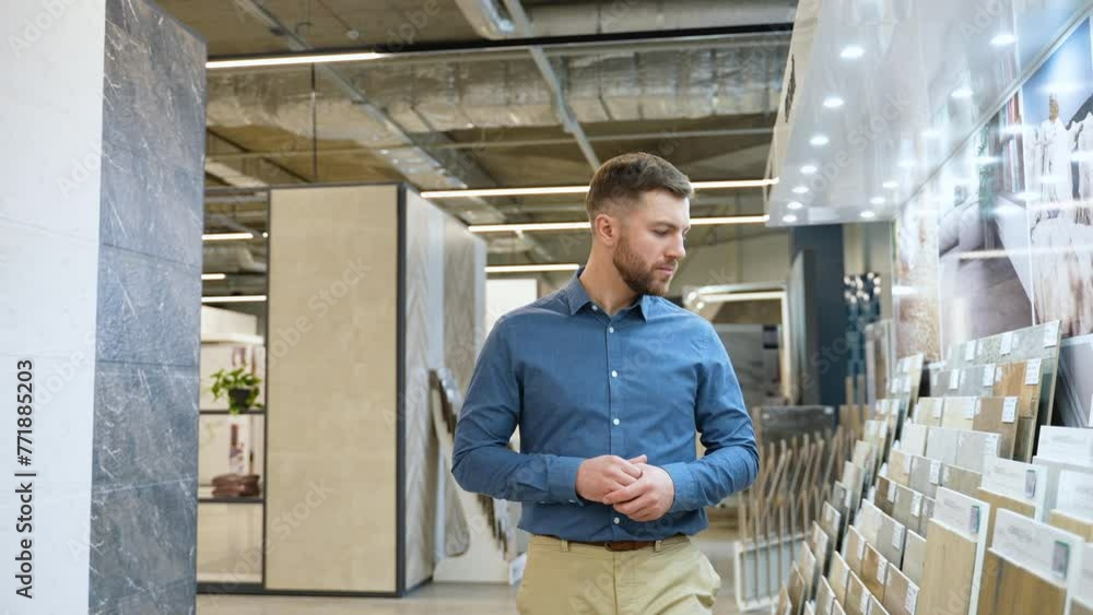 Handsome man walking at luxury shop and chooses tiles Handsome man walking at luxury shop and chooses tiles