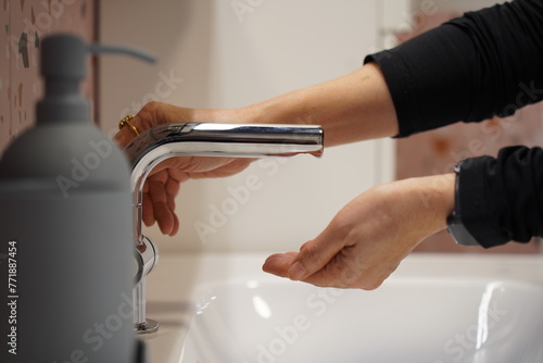 woman washing her hands with liquid soap or shower gel in bathroom