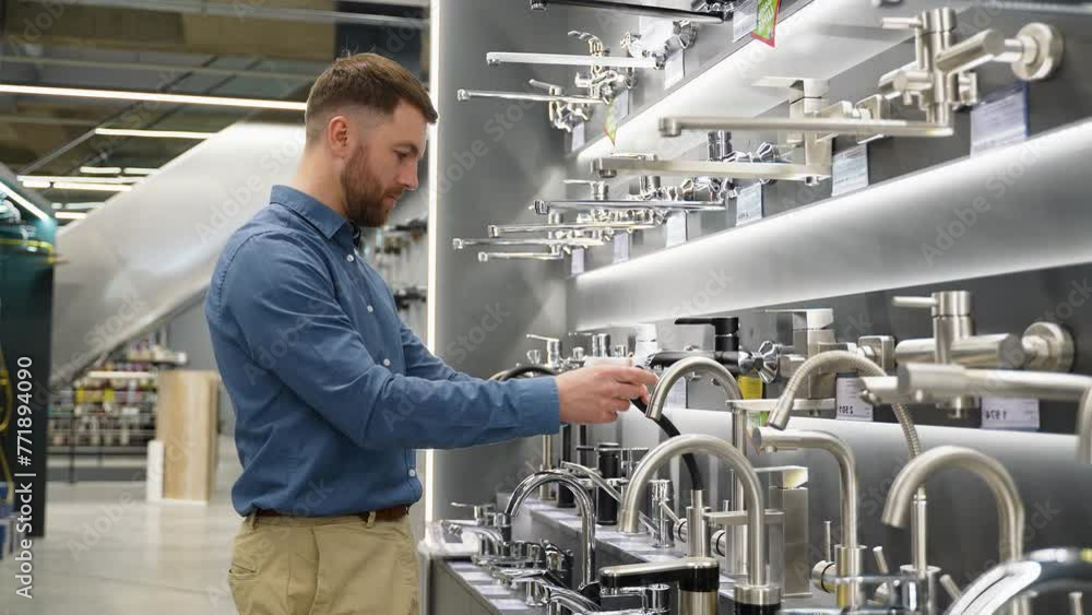 A man chooses a water tap in luxury plumbing store A man chooses a water tap in luxury plumbing store