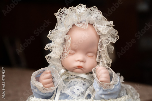 Realistic baby doll on music box with lace and bows decorations