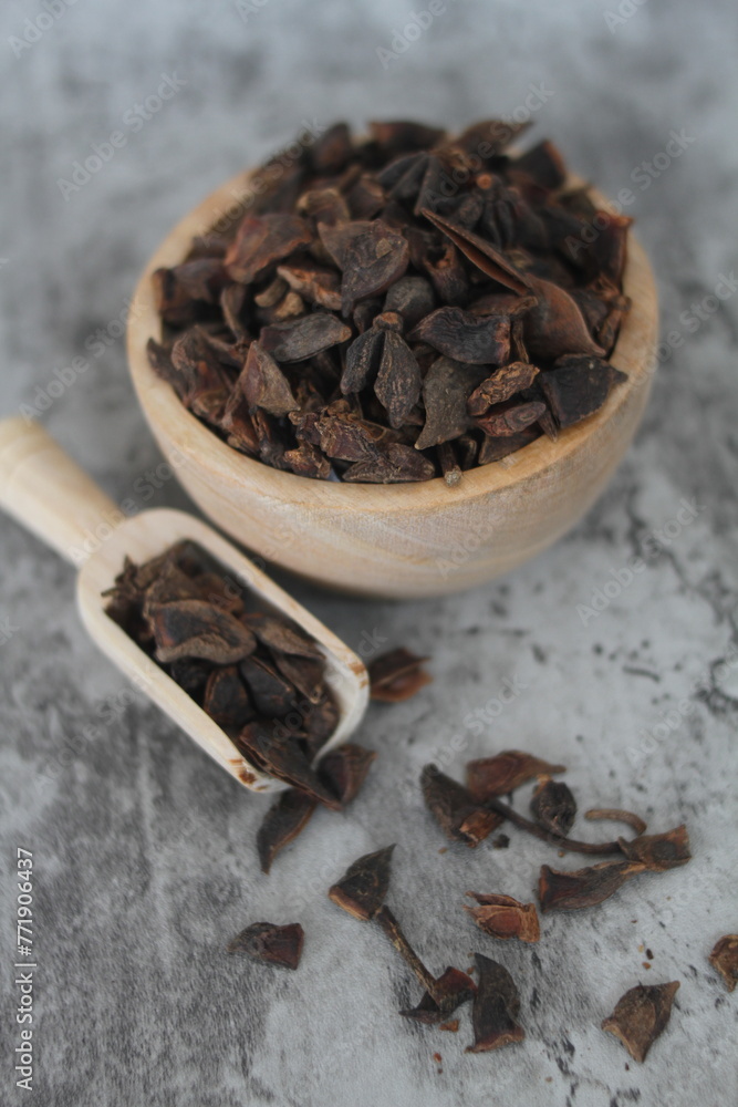 Obraz premium star anise in a wooden bowl on the table, close up