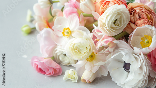 a bouquet of ranunculus  anemone and daffodils lies on a gray background. a delicate background of spring flowers.