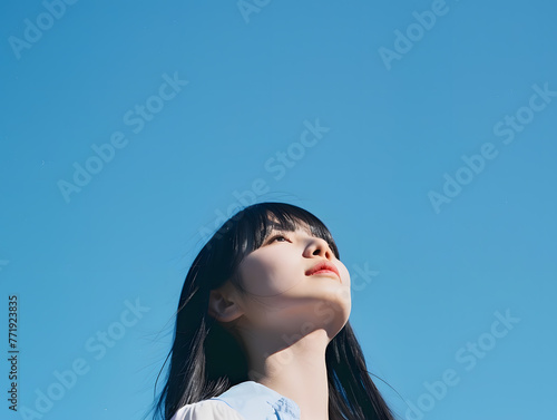 青空を見上げるアジア人女性