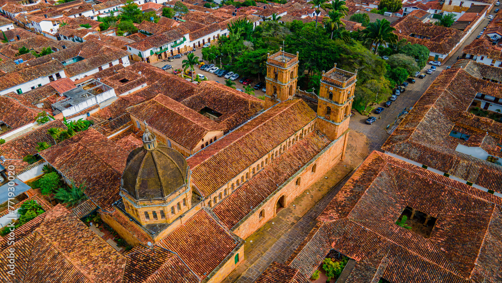 Aerial view of Barichara, showcasing historic architecture, terracotta roofs, and an iconic church amidst lush greenery