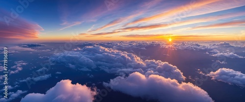 The majestic sunset paints the sky above a soft and ethereal cloudscape, creating a mesmerizing sight